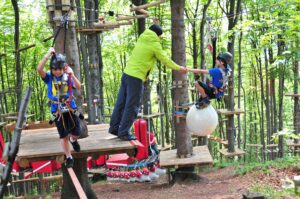 Chłopiec pokonujący tor przeszkód – ćwiczenie orientacji w przestrzeni i równowagi pod okiem trenera.